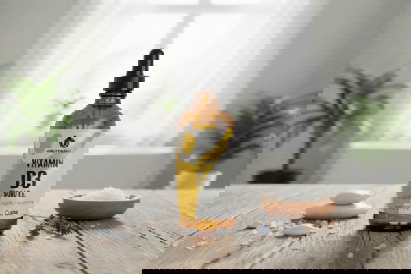 Vitamin D3 5000 I E Tropfenflasche von Kräuterland auf Holztisch mit natürlicher Dekoration in heller Küche