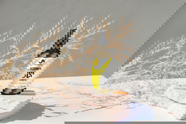 Vitamin D3 K2 Tropfenflasche von Kräuterland auf hellem Podest mit natürlichen Deko Elementen