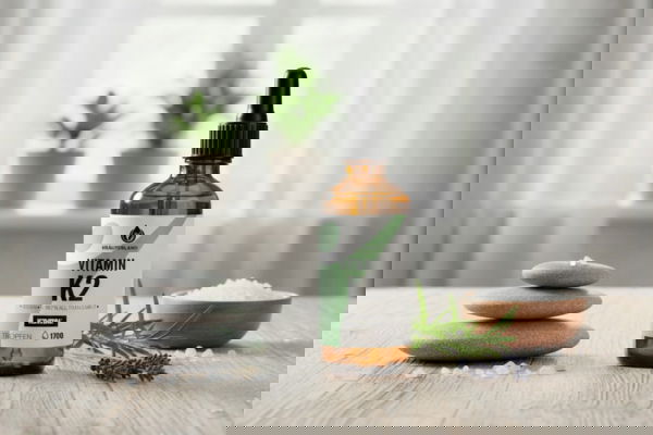 Vitamin K2 Tropfenflasche von Kräuterland auf Holztisch mit natürlicher Dekoration in heller Küche