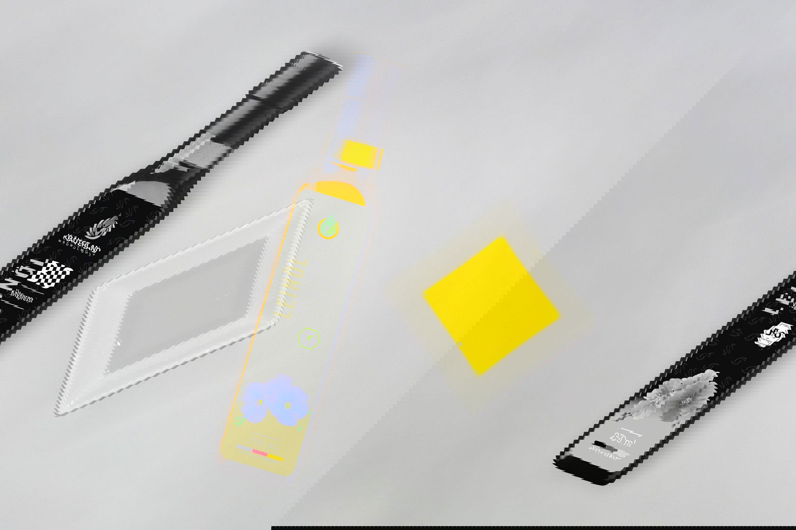 Kräuterland Bio Leinöl 250 ml kaltgepresst in Glasflasche neben Schälchen mit dem gleichen goldgelben Öl zur Veranschaulichung der Farbe