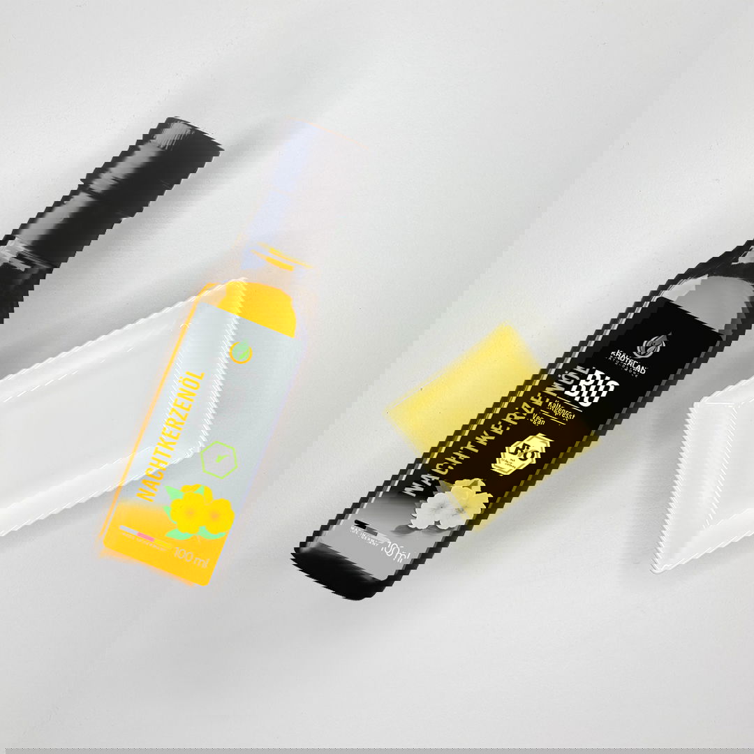 Bio Nachtkerzenöl von Kräuterland neben einer Schale mit hellgoldenem Öl auf hellem Hintergrund