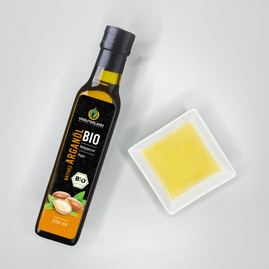 bio-arganoel-produkt Kräuterland Bio Arganöl kaltgepresst in Glasflasche neben Schälchen mit dem gleichen goldgelben Öl zur Veranschaulichung