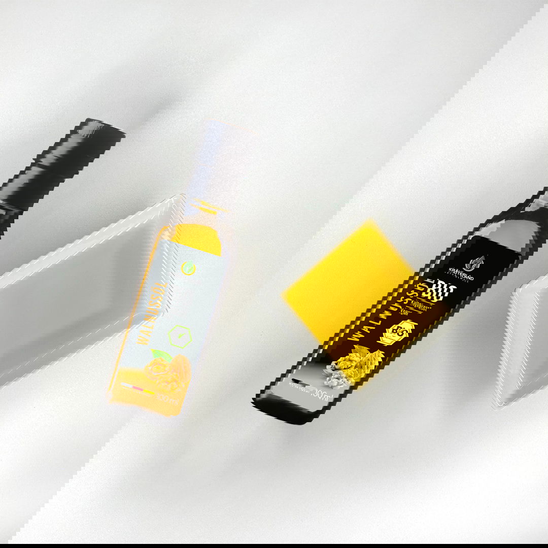 Bio Walnussöl von Kräuterland neben einer Schale mit goldgelbem Öl auf hellem Hintergrund