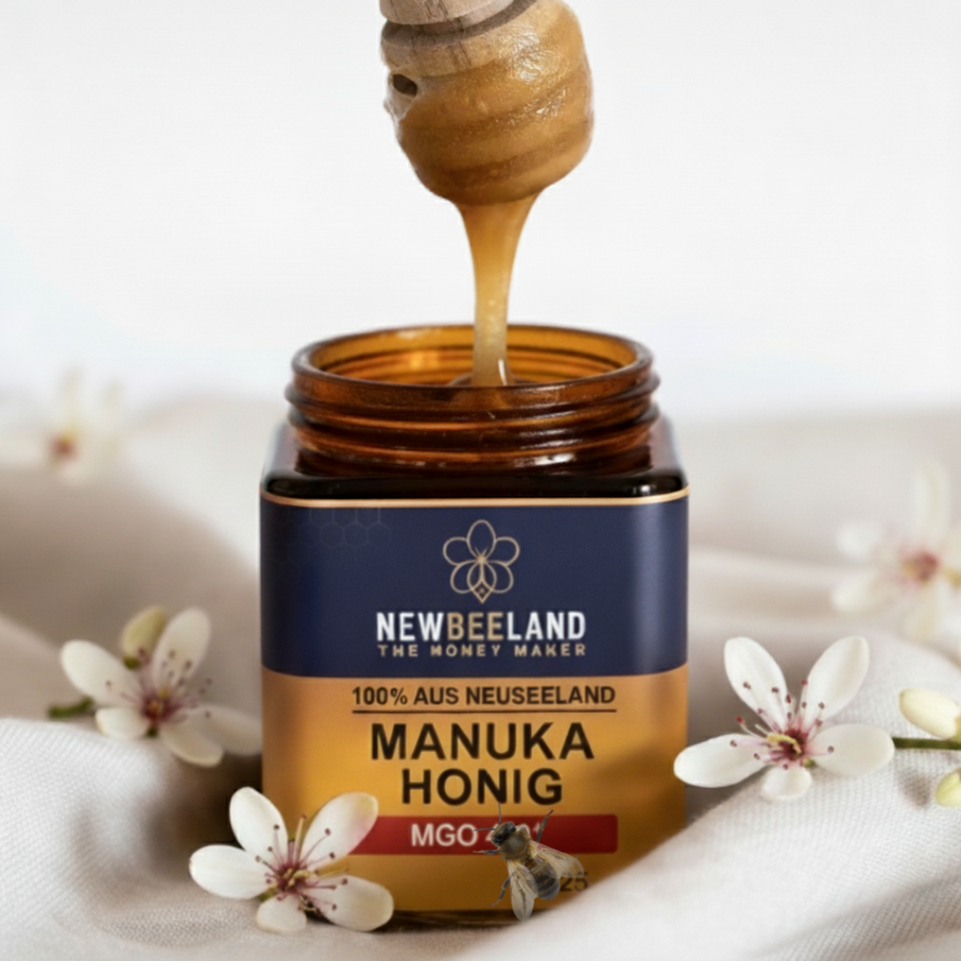 Offenes Glas NewBeeLand Manuka Honig MGO 250+ mit tropfendem Honiglöffel, dekoriert mit weißen Manuka-Blüten und Honigbiene im Vordergrund.